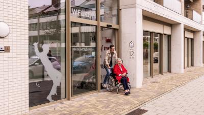 Man duwt vrouw in rolstoel