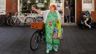 Vrouw met fiets voor de "Buurtkeuken"