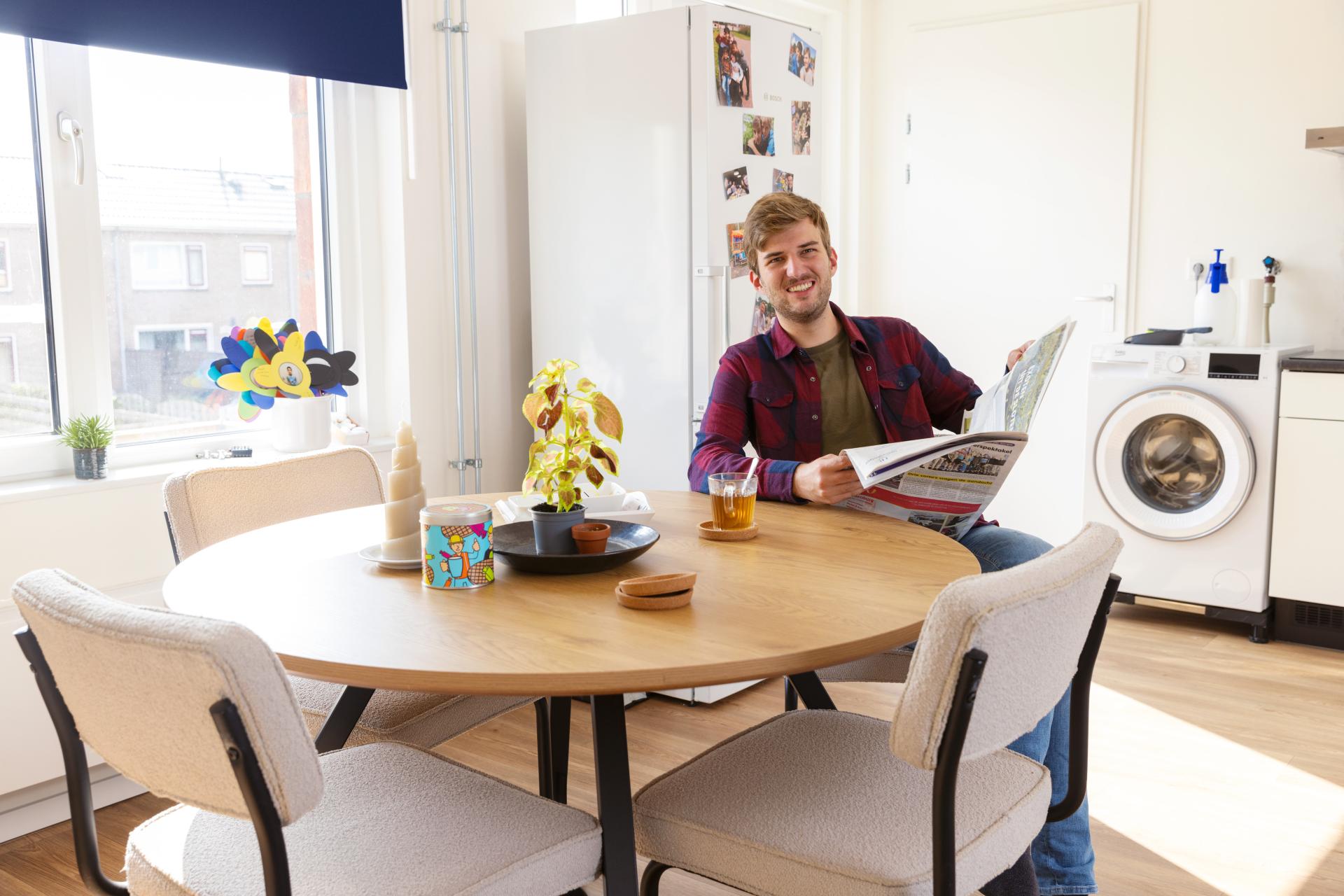 Man aan tafel met krant