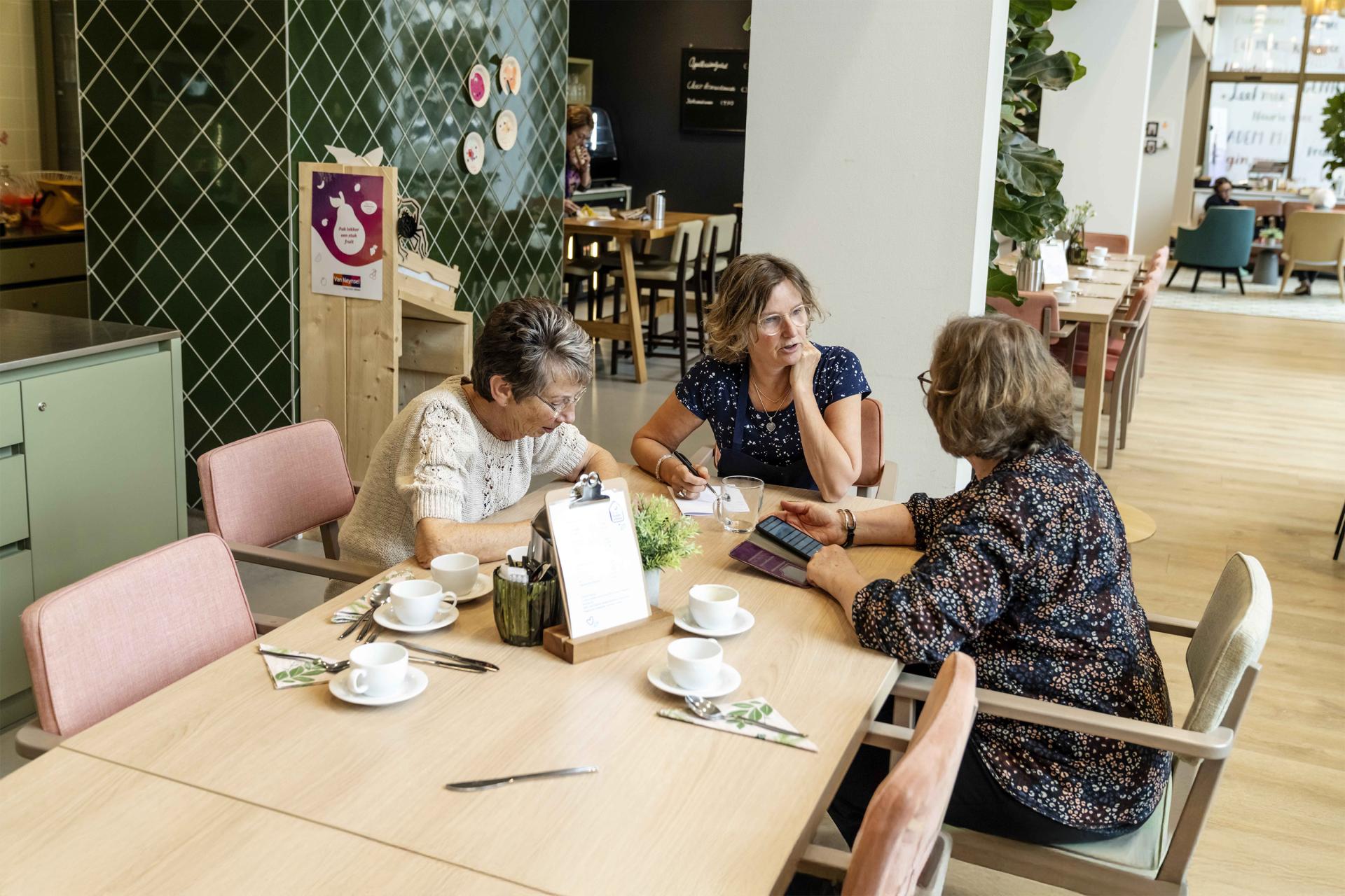 3 mensen in overleg aan tafel