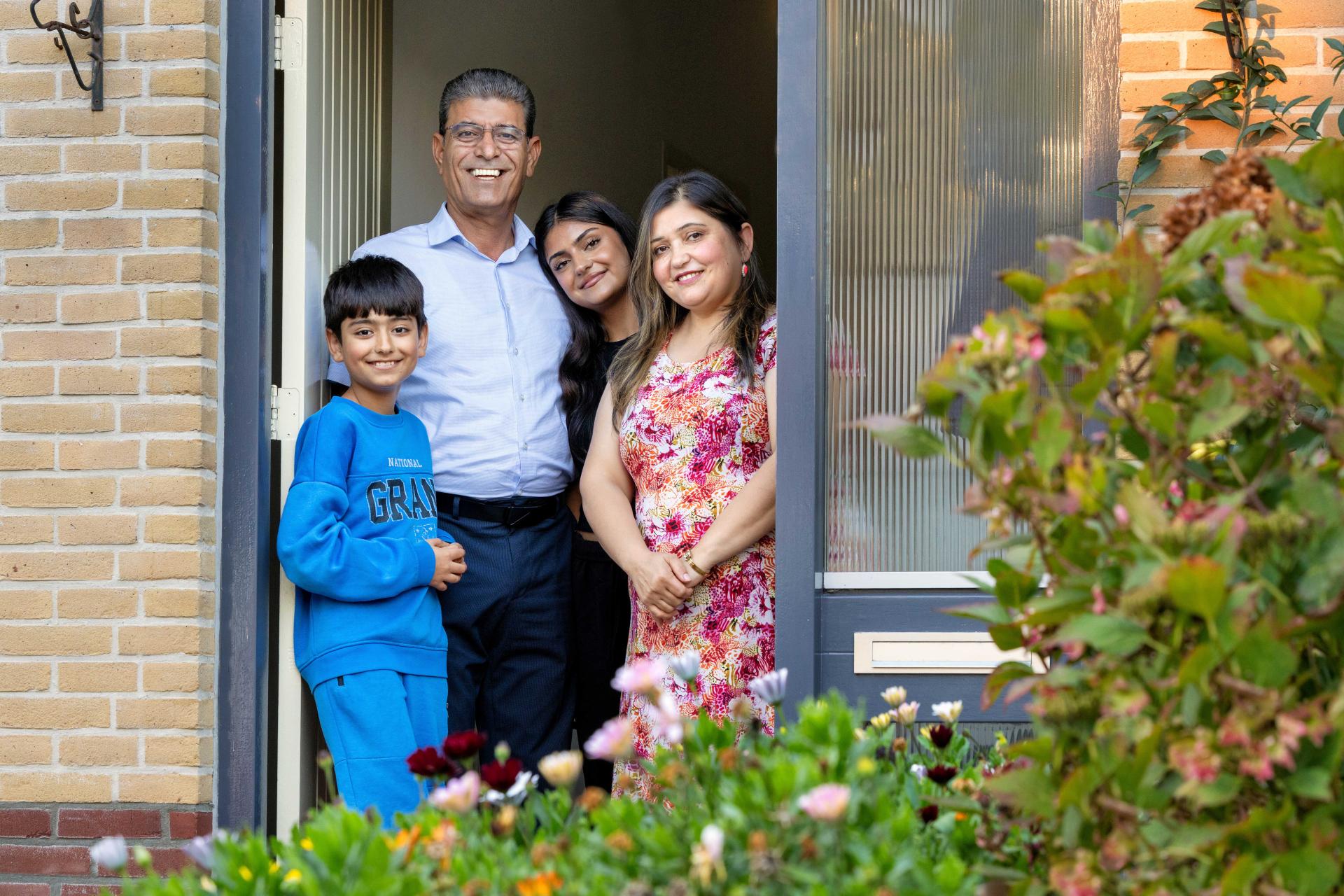 Aladin Mustafa met zijn gezin in de deuropening van hun woning