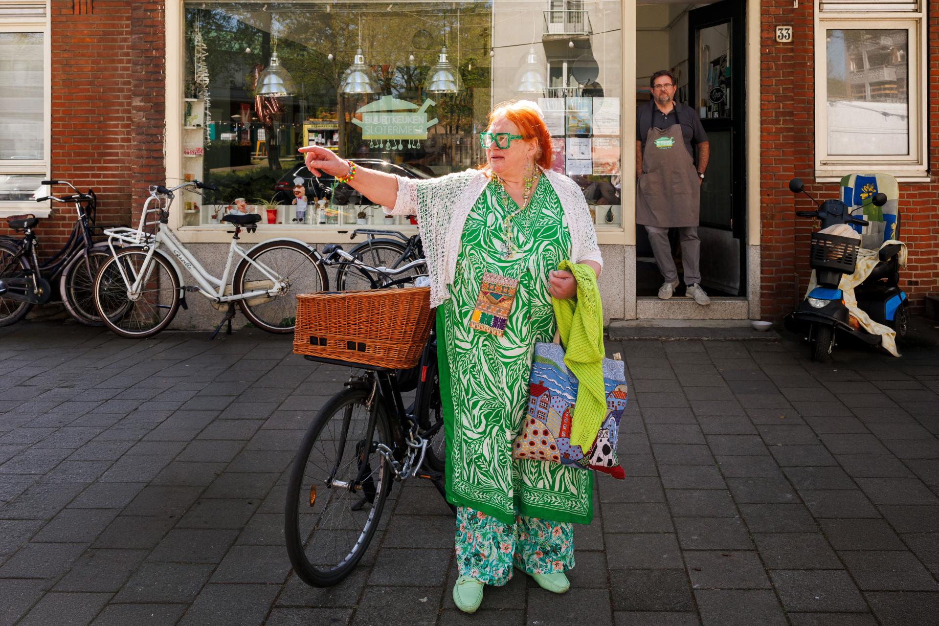 Vrouw met fiets voor de "Buurtkeuken"
