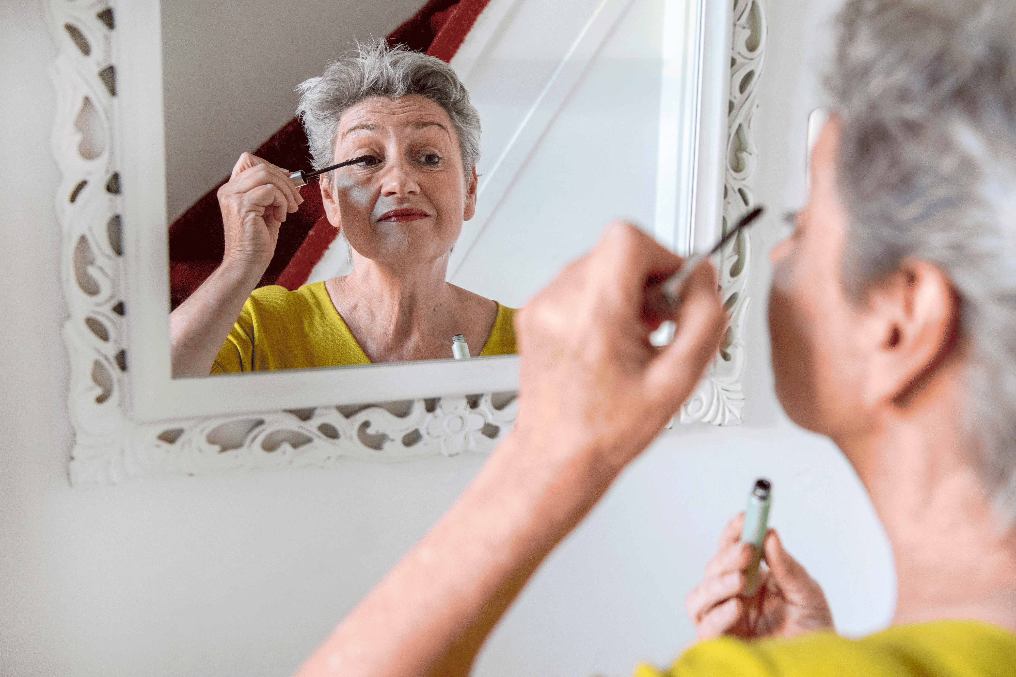 bestuurder van woningcorporatie Mooiland Carly Jansen kijkt in de spiegel en werkt haar make-up bij 