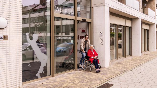 Man duwt vrouw in rolstoel