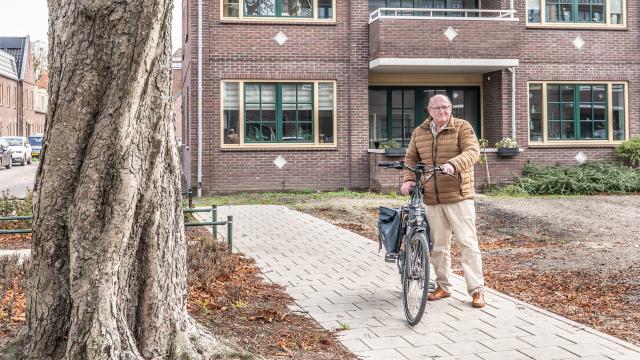 Man loopt met fiets aan de hand