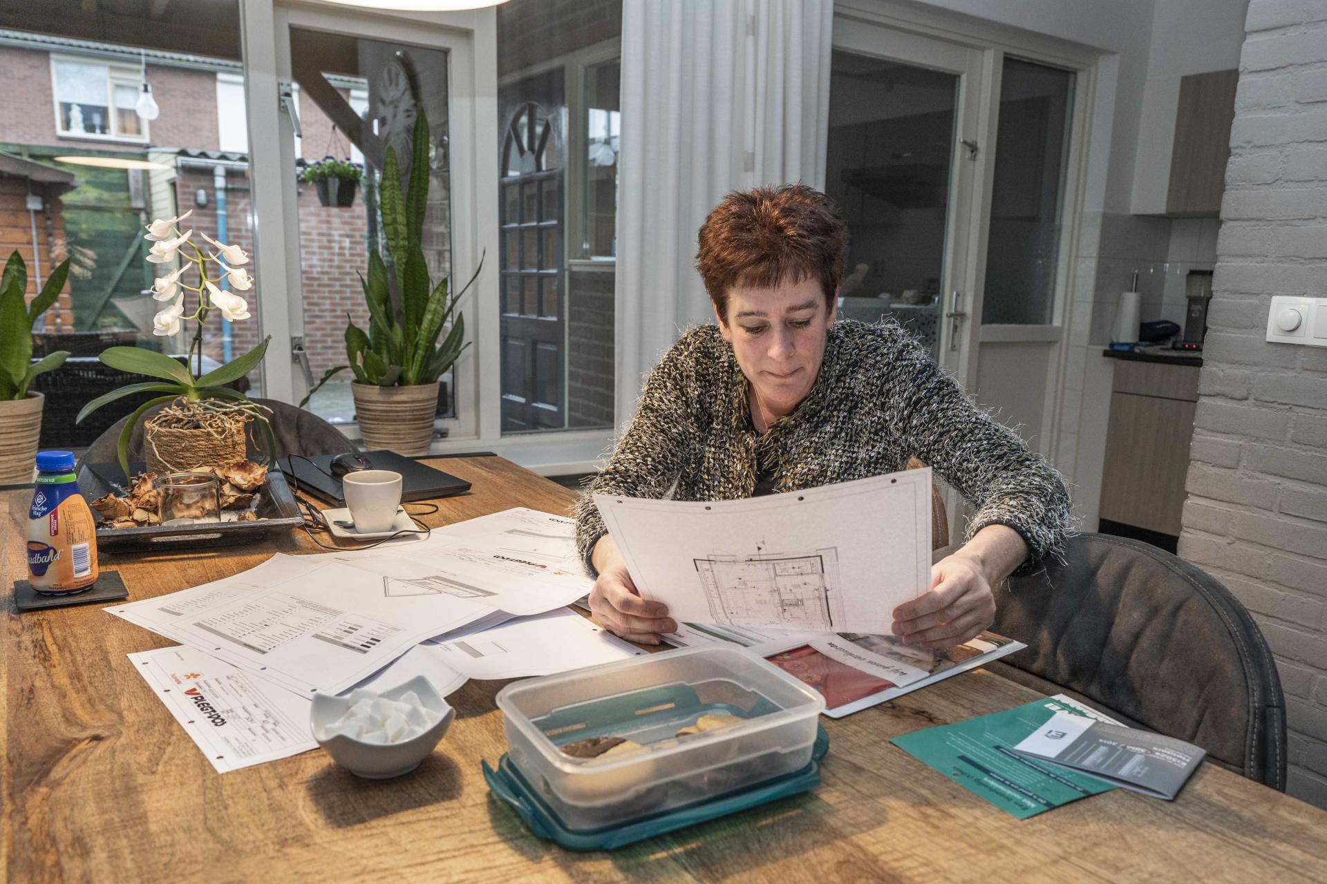 Rita Berendsen bekijkt bouwtekeningen
